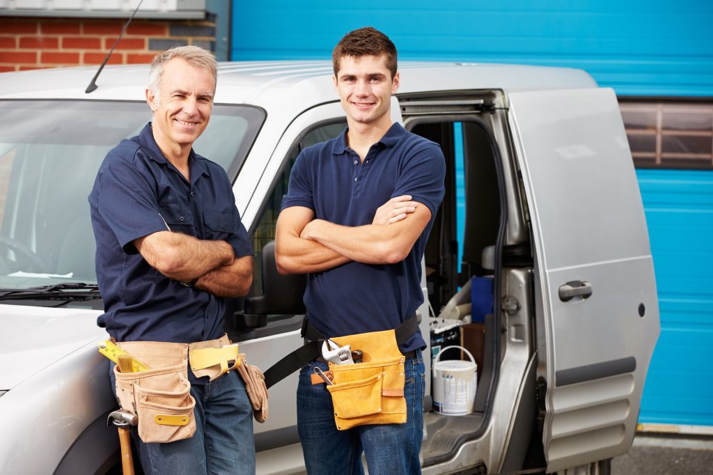 workers in family business standing next to van